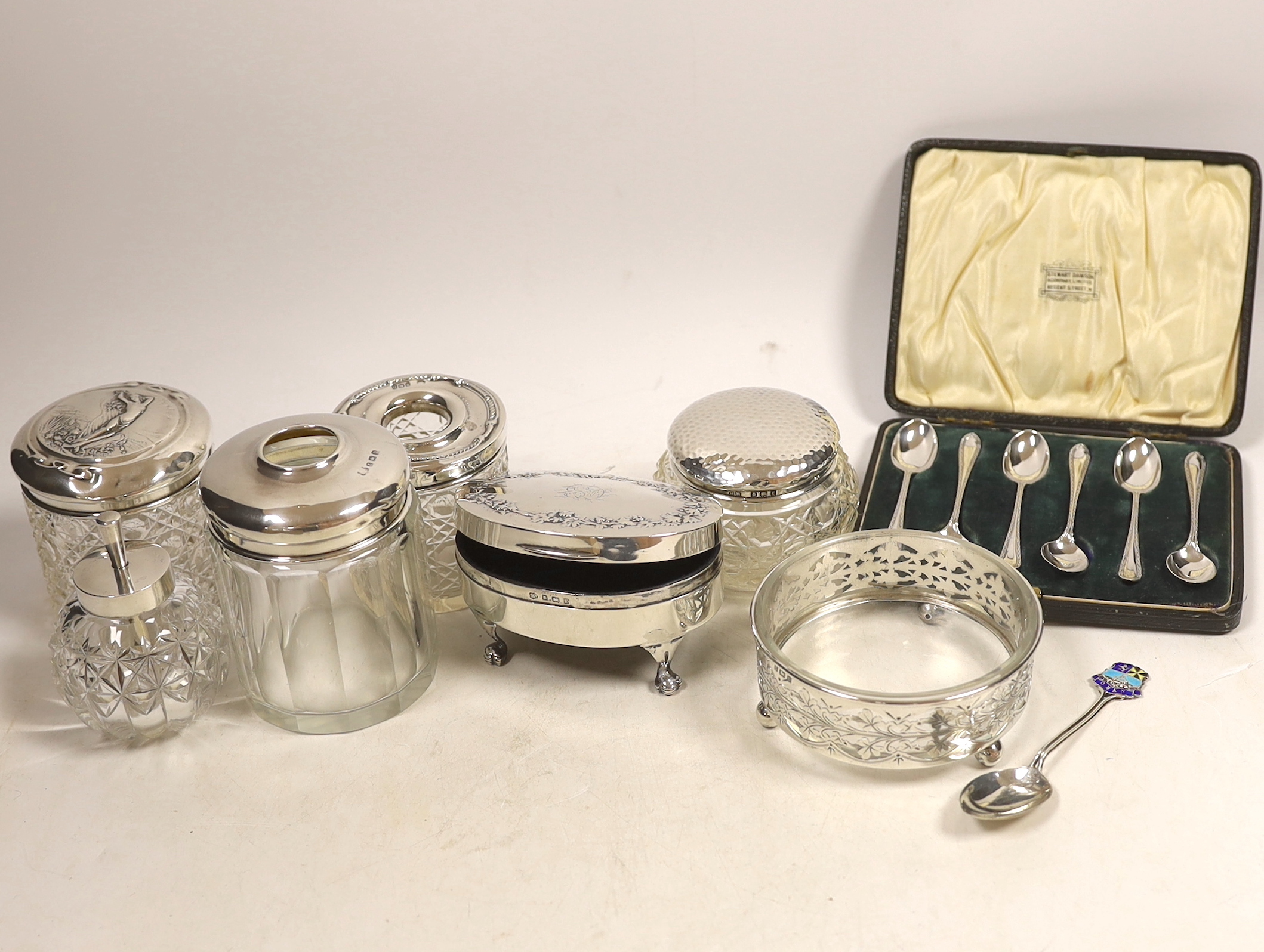 An Edwardian silver mounted oval trinket box, Birmingham, 1905, 98mm and other items including a cased set of six silver coffee spoons, mounted toilet jars, etc.